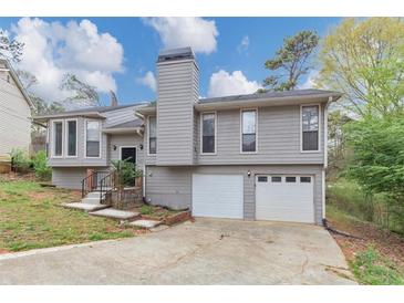 Charming home featuring a two-car garage, gray siding, and a well-maintained front yard at 2780 Creekwood Ln, Lawrenceville, GA 30044