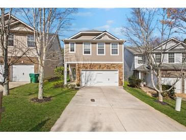 Charming two-story home featuring stone accents, a two-car garage, and a well-manicured front lawn at 313 Hidden Creek Lane, Canton, GA 30114