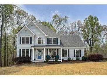 Traditional two-story home with a manicured lawn, charming front porch, and classic architectural details at 819 Holly Rdg, Canton, GA 30115