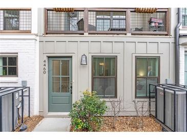 Charming townhome exterior featuring a cozy balcony and stylish front door with attractive landscaping at 4460 Dalston Ne Dr, Atlanta, GA 30342