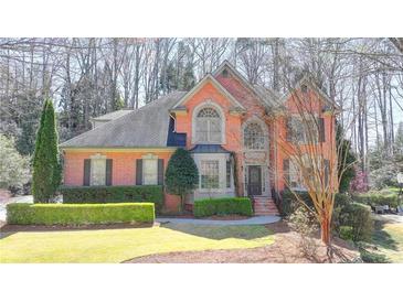 Charming two-story brick home featuring well-manicured landscaping and a welcoming front entrance at 5190 Deerlake Dr, Alpharetta, GA 30005