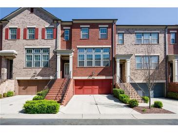 Charming townhome with red brick facade, garage, and well-maintained landscaping at 1096 Holly Ave, Atlanta, GA 30338