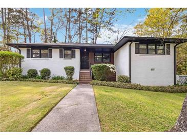 Charming white brick home with landscaped front yard and a stone walkway leading to the entrance at 2267 Bryant Dr, East Point, GA 30344