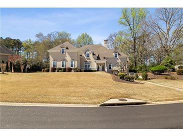Beautiful two-story home with a well-manicured lawn and mature trees, offering great curb appeal at 3720 River Mansion Dr, Peachtree Corners, GA 30096