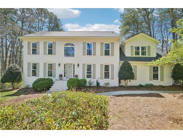 Charming two-story home featuring a white brick facade, complemented by lush greenery and a well-manicured front yard at 1260 Centenary Rdg, Snellville, GA 30078