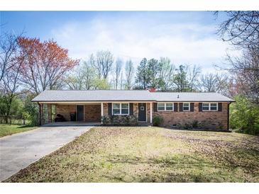 Charming brick ranch with a carport, a well-manicured lawn, and a welcoming front entrance at 6348 Garnet Dr, Douglasville, GA 30135