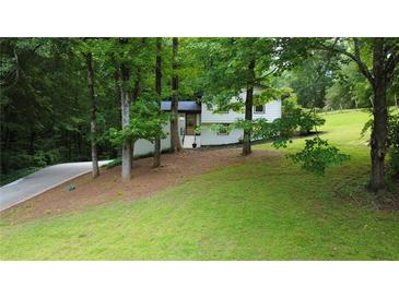 Charming two-story home with a well-manicured lawn and driveway tucked among mature trees at 3306 Sleepy Se Ln, Smyrna, GA 30080