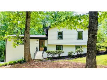 Charming split-level home featuring a brick facade, new windows, and lush landscaping at 3306 Sleepy Se Ln, Smyrna, GA 30080