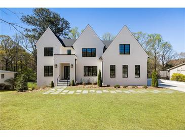New construction featuring a bright white brick home with black window trim and a manicured lawn at 312 Meadow Dr, Alpharetta, GA 30009