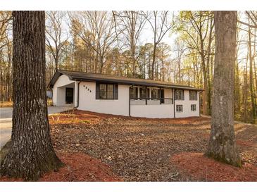 Charming single-story home with a white brick exterior and mature trees in a peaceful setting at 4336 Parkview Dr, Lithia Springs, GA 30122