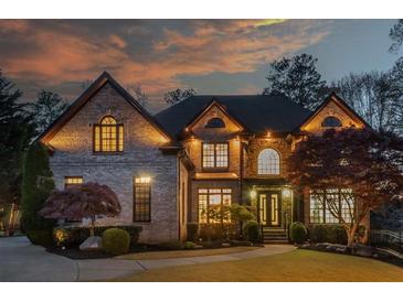 Stunning brick home featuring manicured landscaping, arched windows, and a warm inviting entrance at 2461 Oak Grove Ne Ests, Atlanta, GA 30345