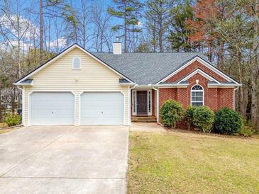 Charming single-story home boasts a two-car garage, brick accents, and a well-maintained lawn at 57 Sorghum Ct, Dallas, GA 30157