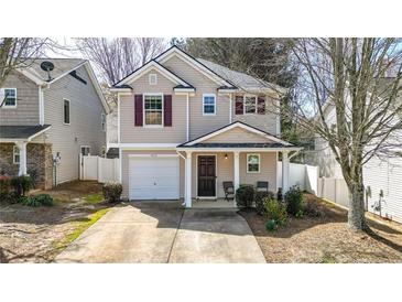 Charming two-story home featuring neutral siding, a single-car garage, and a cozy front porch at 411 Sureyya Dr, Canton, GA 30114