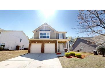 Charming two-story home featuring a brick-accented facade, manicured lawn, and a two-car garage at 40 Kingfisher Walk, Covington, GA 30014