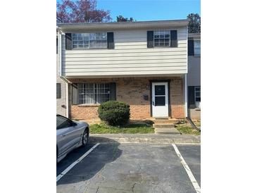 Two-story townhouse featuring brick and siding, complemented by black shutters and a paved parking area at 4701 Flat Shoals Rd, Union City, GA 30291