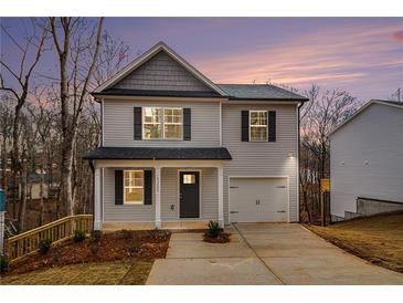 Charming two-story home with gray siding, black shutters, and a well-maintained front yard at dusk at 6355 Akins Way, Cumming, GA 30041