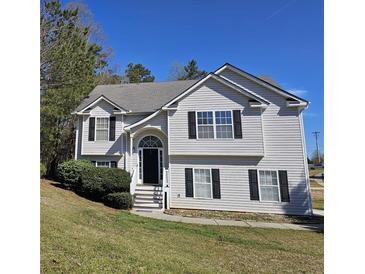 Charming two-story home with black shutters, arched entry and well-maintained lawn on a sunny day at 68 Georgias Ln, Dallas, GA 30157