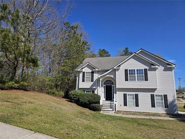 Charming two-story home with vinyl siding and a well-manicured lawn on a sunny day at 68 Georgias Ln, Dallas, GA 30157