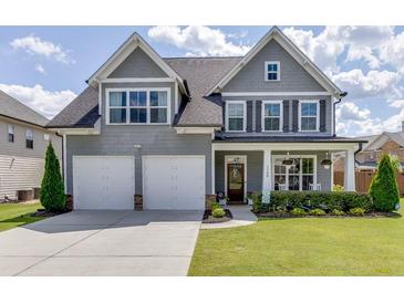 Charming two-story home featuring a two-car garage, manicured lawn, and covered front porch at 1788 Hanover West Ct, Lawrenceville, GA 30043