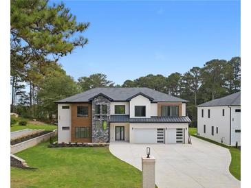 Stunning new construction home with a modern design, three-car garage and lush landscaping at 3240 Miller Bottom Rd, Conyers, GA 30012