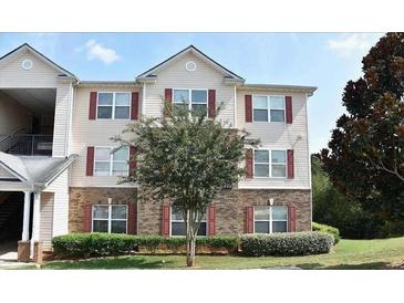 Charming condo building featuring brick and siding accents, complemented by a well-maintained lawn and mature trees at 5204 Waldrop, Decatur, GA 30034