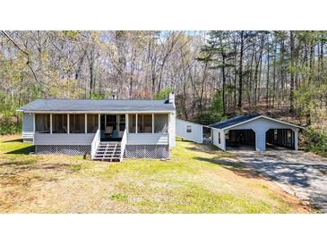 Charming home featuring a screened porch, detached garage, and a peaceful, wooded lot at 528 Lower Scott Mill Rd, Canton, GA 30114