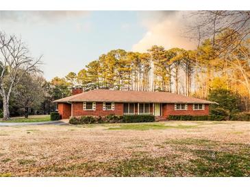 Charming brick ranch-style home with a well-maintained lawn and mature trees in a tranquil setting at 3856 Egypt Rd, Snellville, GA 30039