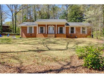 Charming brick home with a covered front porch and classic white trim and a well-manicured front yard at 6339 Cornelia Dr, Douglasville, GA 30134