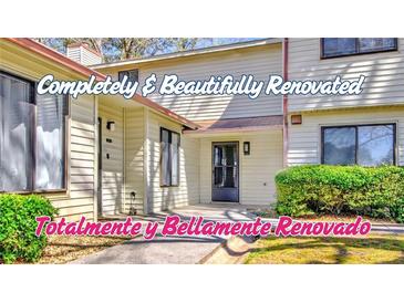 Renovated townhouse with cream siding and well-maintained landscaping at 1124 Country Ct, Lawrenceville, GA 30044