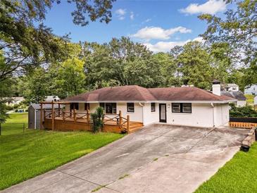 Charming ranch-style home featuring a wooden deck, white brick exterior, and well-manicured front lawn at 215 Collum Nw St, Atlanta, GA 30314