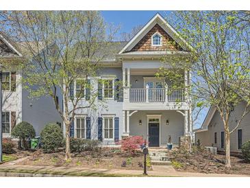 Charming two-story home with a welcoming front porch and beautifully landscaped front yard with flowering trees at 489 Carter Se Ave, Atlanta, GA 30317