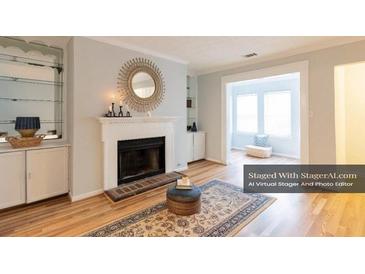 Bright living room featuring a fireplace, hardwood floors, and decorative wall mirror at 1941 Brian Way # 1941, Decatur, GA 30033
