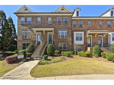 Charming brick townhome features a well-manicured lawn, inviting entrance, and classic architectural details at 3022 Hartford Mill, Duluth, GA 30097