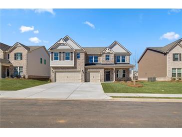 Beautiful two-story brick home with a three car garage and well-manicured front lawn at 2781 Dolce Rd, Dacula, GA 30019