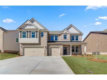 Beautiful two-story brick home with a three-car garage and well-manicured front lawn at 2781 Dolce Rd, Dacula, GA 30019