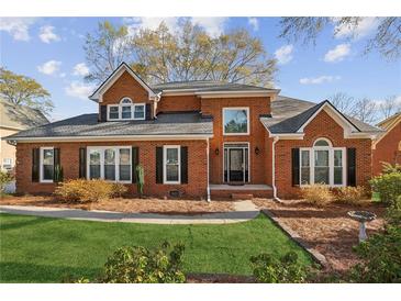 Beautiful two-story brick home with manicured lawn, mature shrubs, and a classic design at 321 Covered Bridge Sw Pl, Smyrna, GA 30082