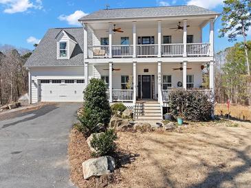 Charming two story home featuring a double porch, manicured landscaping, and attached two car garage at 8470 Wallace Tatum Rd, Cumming, GA 30028