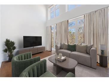 Bright living room features high ceilings, large windows, neutral decor, and comfortable seating arrangement at 1221 Caroline Ne St # 201, Atlanta, GA 30307