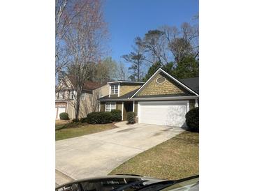 Charming home featuring a well-maintained lawn, complemented by a two-car garage and beautiful landscaping at 8236 Eastshore Dr, Union City, GA 30291