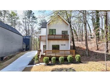New construction modern home with a white facade, wood-accented balconies and a welcoming front porch at 1800 Charles Nw Pl, Atlanta, GA 30318