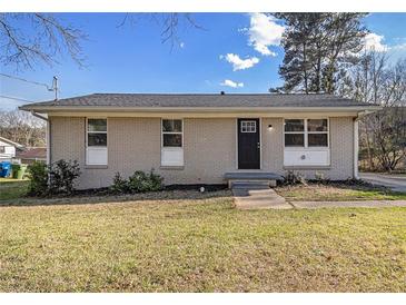 Charming single-story home featuring a neutral brick exterior, black front door, and well-manicured lawn at 4062 Doster Sw Dr, Atlanta, GA 30331