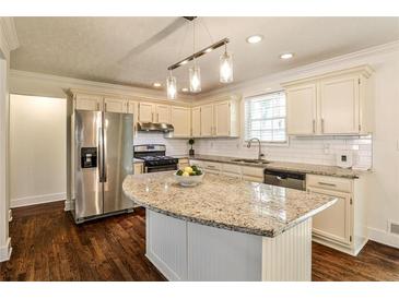 Bright eat-in kitchen features an island, stainless steel appliances, and white subway tile backsplash at 3427 Springlake Dr, Decatur, GA 30032