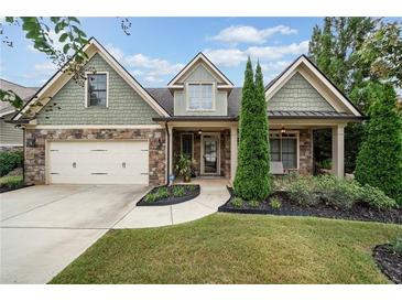 Charming home featuring stone and shingle accents, manicured lawn and an attached two car garage at 3124 Bentgrass Ln, Kennesaw, GA 30144