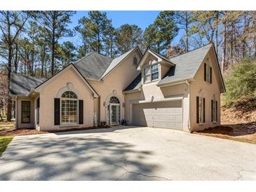 Charming two-story home featuring a well-manicured lawn, a welcoming entrance, and an attached garage at 5163 Holly Springs Dr, Douglasville, GA 30135