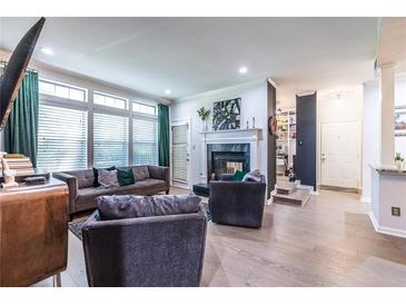 Bright living room featuring a fireplace, modern furniture, and large windows at 240 Renaissance Ne Pkwy # 106, Atlanta, GA 30308