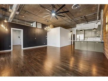 Contemporary living room with hardwood floors, industrial ceiling, and open kitchen space at 3235 Roswell Ne Rd # 421, Atlanta, GA 30305
