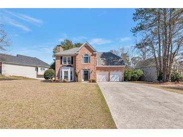 Charming brick home featuring a well-manicured lawn and a two-car garage at 1561 Cooks Pond Dr, Powder Springs, GA 30127