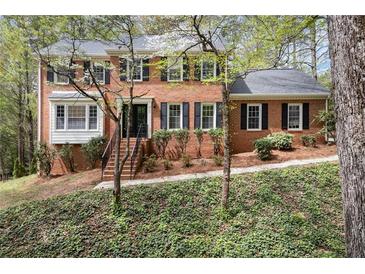 Charming two-story brick home with a landscaped front yard and mature trees, offering classic curb appeal at 2115 Hawthorne Pt, Marietta, GA 30062