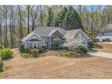 Charming single-Gathering home featuring stone accents and a manicured lawn, set amidst a lush, wooded backdrop at 534 Creekstone Dr, Jonesboro, GA 30236