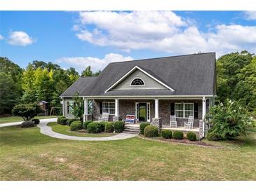 Charming home with a covered front porch, stone accents, and a well-manicured lawn at 12551 Alcovy Rd, Covington, GA 30014